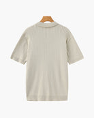 Beige ribbed knit dress on a hanger against a white background