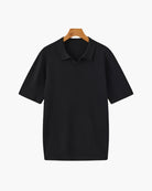 Black ribbed polo shirt on a hanger against a white background