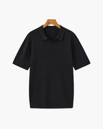 Black ribbed polo shirt on a hanger against a white background