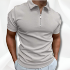 Man wearing a light gray short-sleeve polo shirt with a quarter zip on a white background
