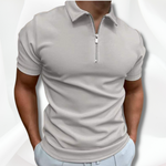 Man wearing a light gray short-sleeve polo shirt with a quarter zip on a white background