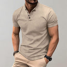 Man wearing a beige polo shirt and pants against a gray background