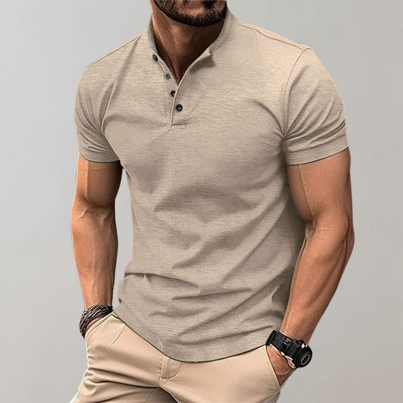 Man wearing a beige polo shirt and pants against a gray background