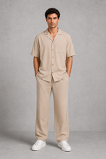 Man wearing a beige shirt and pants set against a gray background