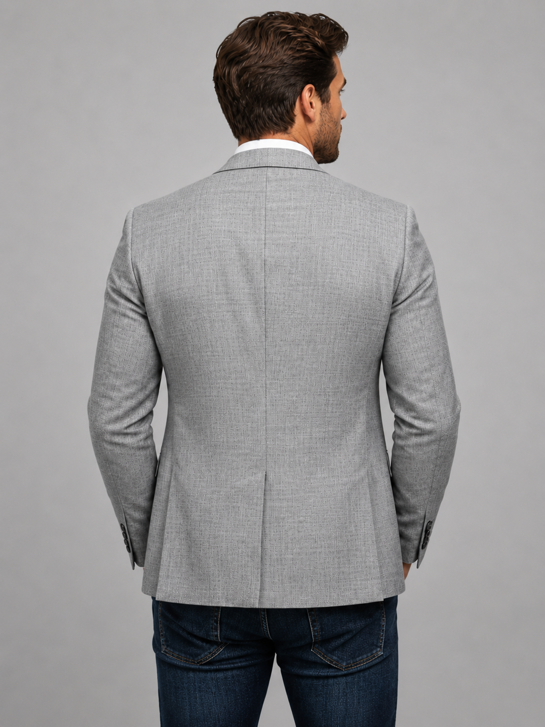 Man wearing a gray checkered blazer on a gray background