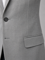Close-up of a gray suit jacket with a button and pocket on a light gray background