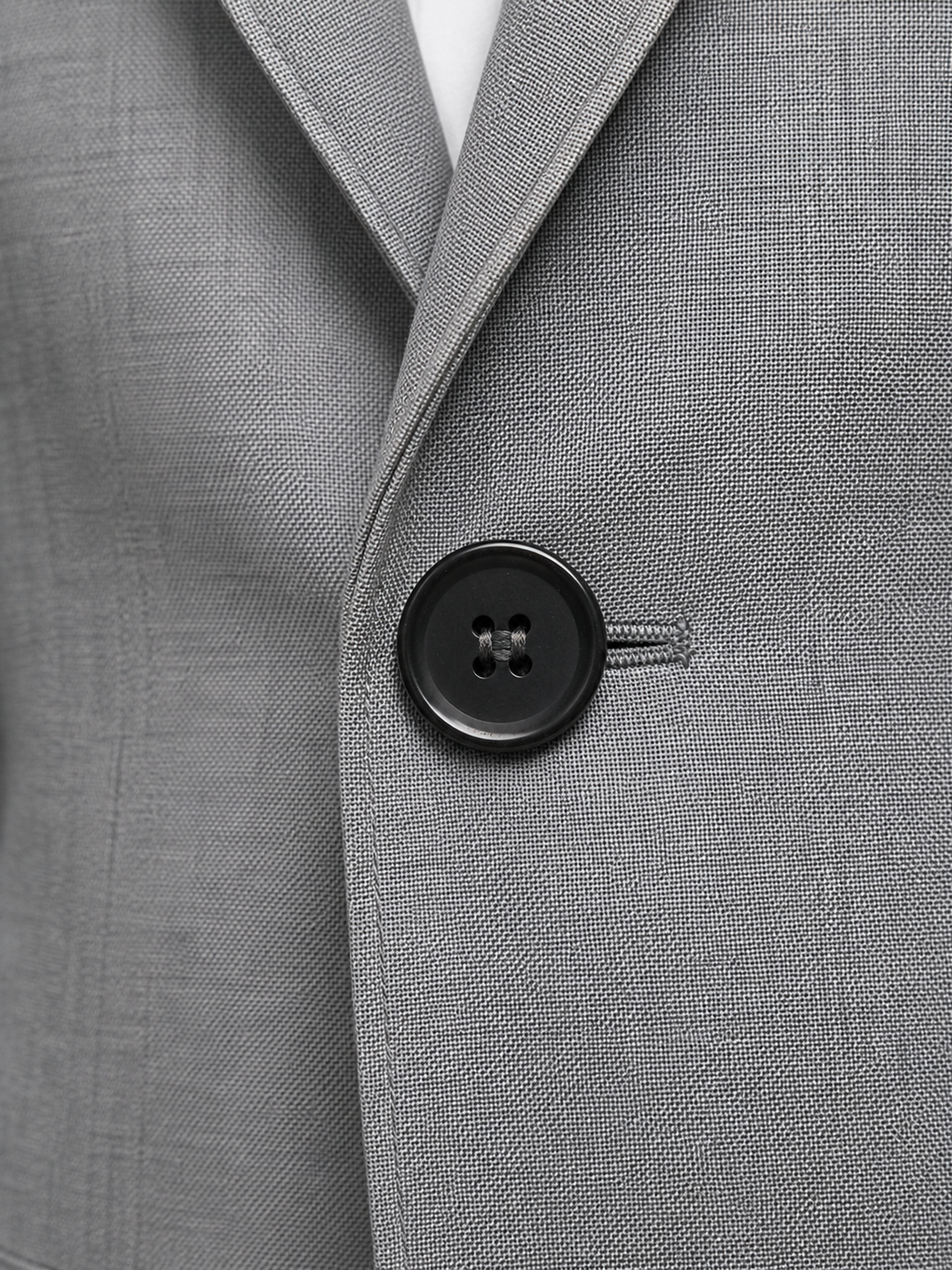 Close-up of a gray suit jacket with a button