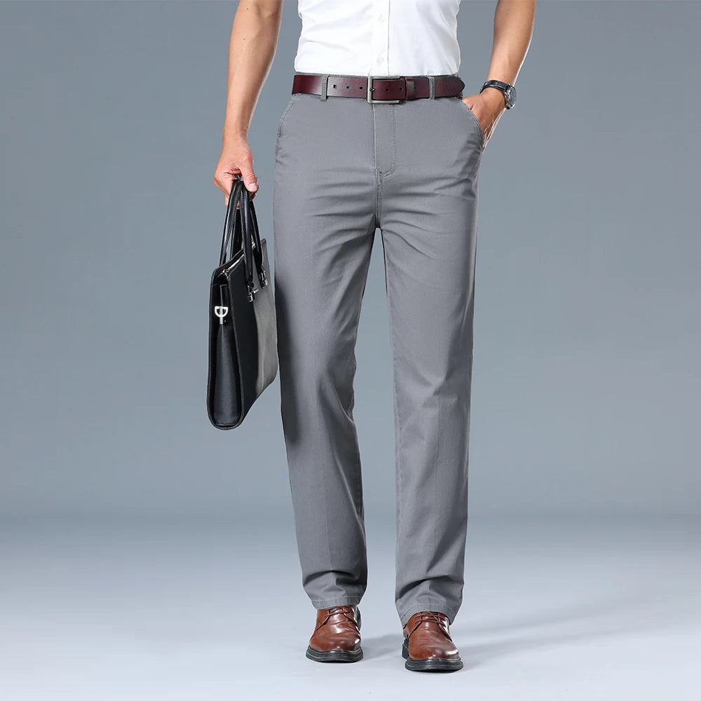 Person wearing gray pants and holding a black briefcase on a gray background