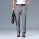 Person wearing gray pants and holding a black briefcase on a gray background