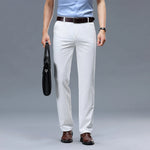 Person wearing white pants, a light blue shirt, and brown shoes on a gray background