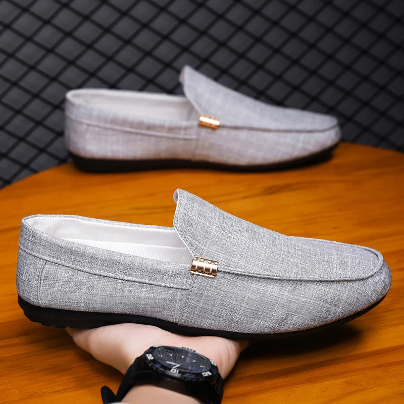 Gray loafers on a wooden surface with a black mesh background
