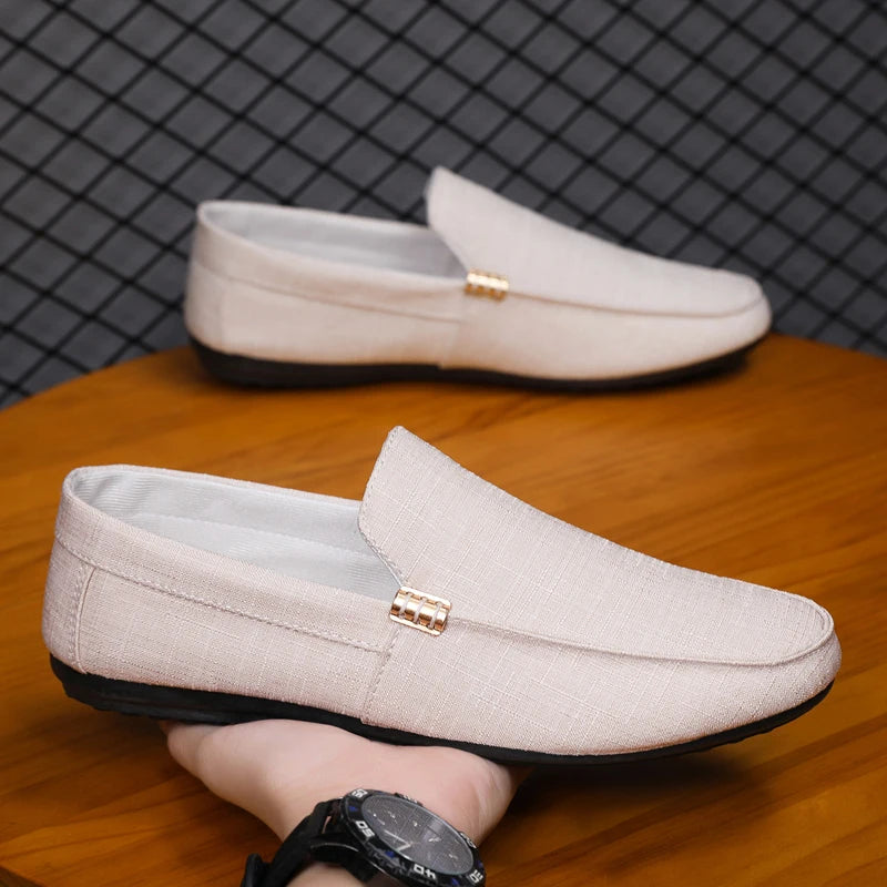 Beige loafers on a wooden surface with a grid-patterned wall in the background