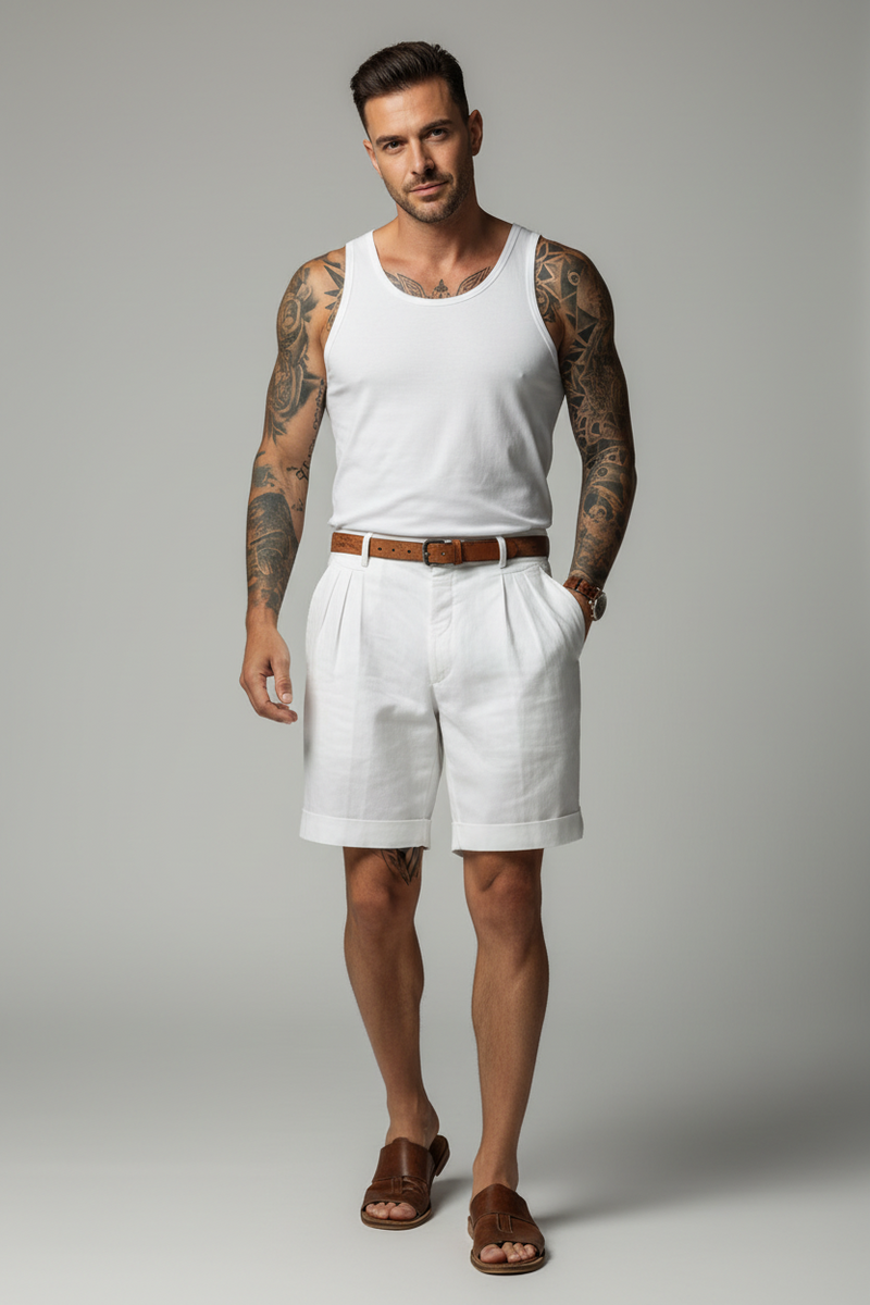 Person wearing white shorts and a white shirt with tattoos on arms, holding a bottle.