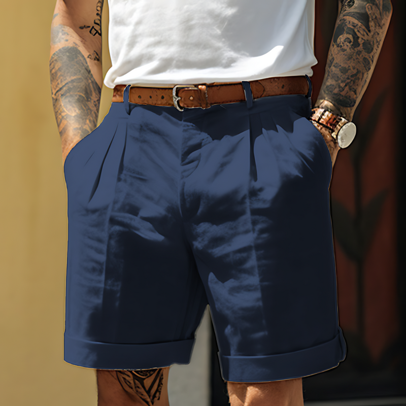 Person wearing navy shorts with a white shirt and brown belt against a blurred background