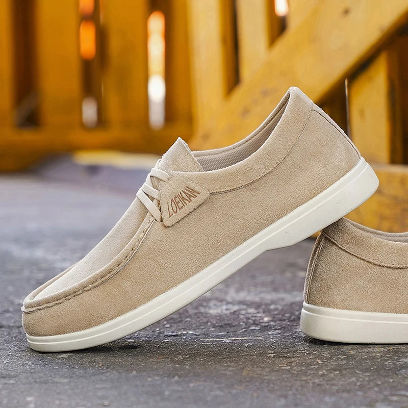 Beige loafers with white soles on a textured surface
