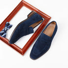 Pair of blue loafers with a bow tie on a white background