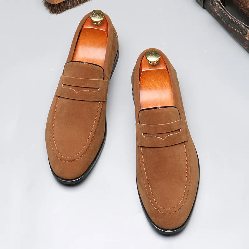 Pair of brown loafers with gold buttons on a light gray background
