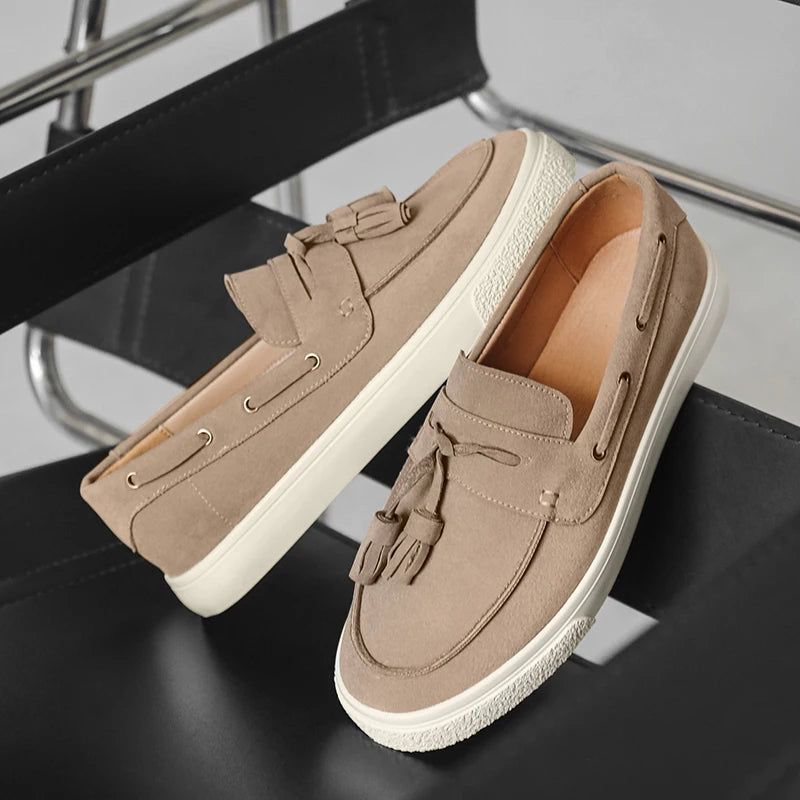 Pair of tan loafers on a chair with a neutral background