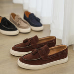 Brown loafers on a wooden floor with a neutral background