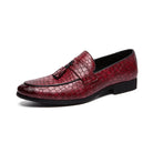 Red leather loafer with a black sole on a white background
