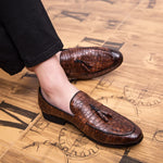 Brown leather loafers worn on a wooden floor