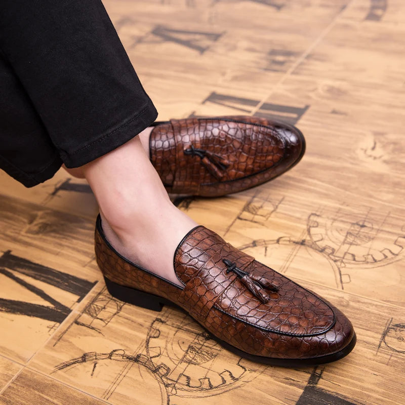 Brown leather loafers worn on a wooden floor