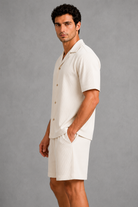 Man wearing a white outfit against a gray background