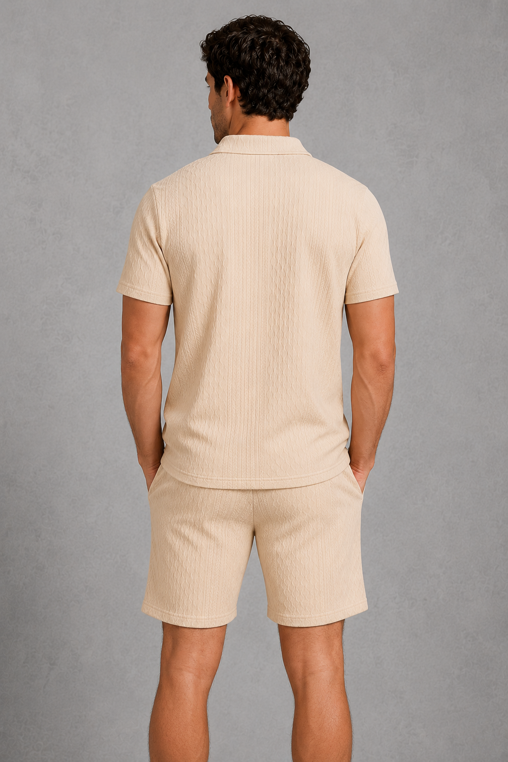 Man wearing a beige polo shirt and shorts against a gray background