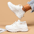 White sneakers worn with a beige background
