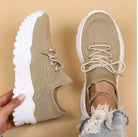 Beige sneakers with white soles worn by a person on a beige background