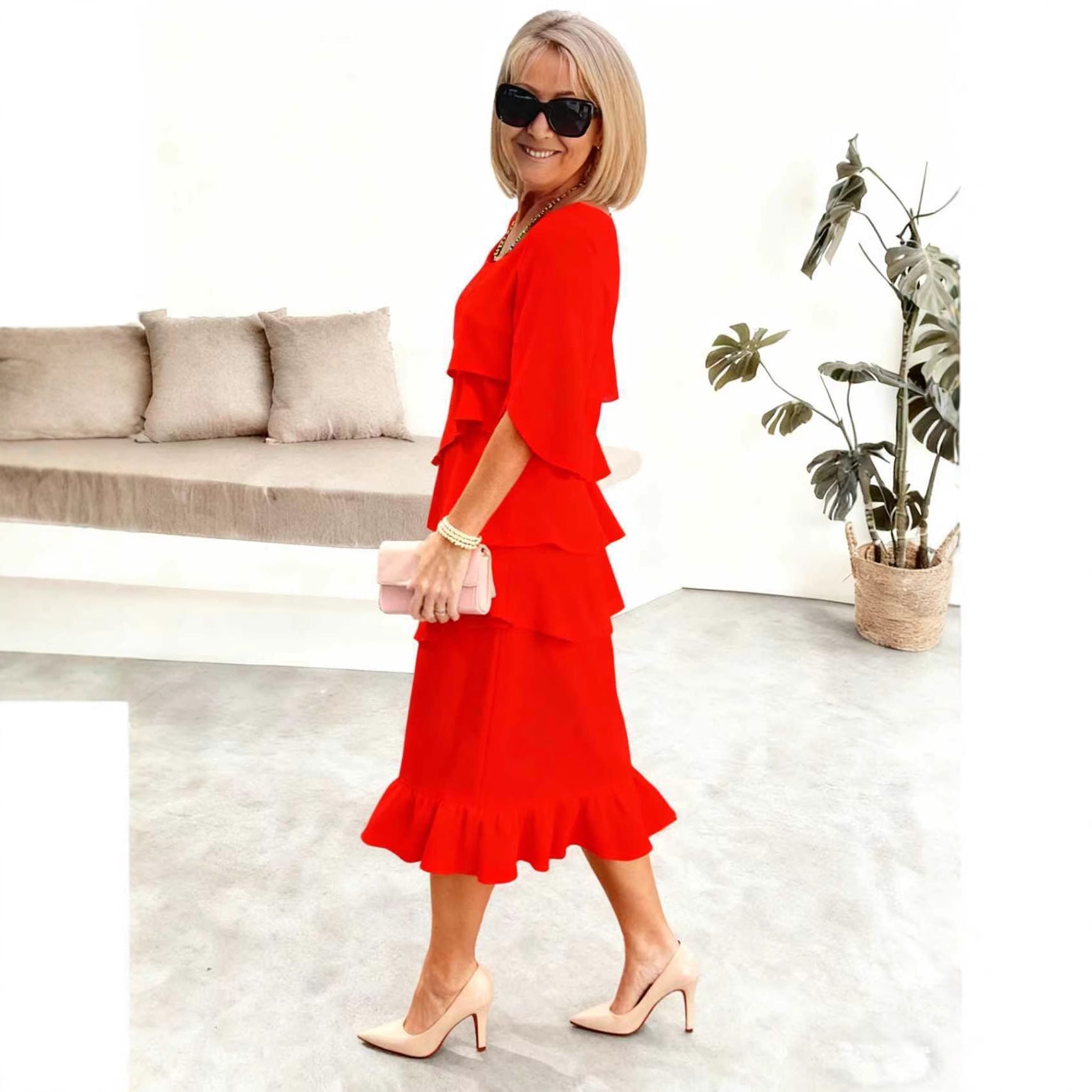 Woman in a red dress standing in a modern living room.