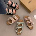 Colorful sandals on a gray surface with a box labeled 'NINE BALI' in the background.