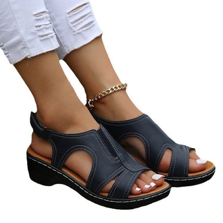 Black sandals worn with light blue denim jeans on a white background