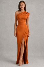 Woman wearing a one-shoulder orange dress with a slit on a gray background