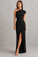 Woman wearing a black one-shoulder dress with a slit on a gray background