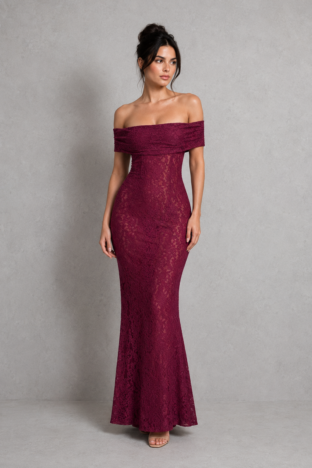 Woman wearing a burgundy off-shoulder lace dress against a gray background