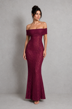 Woman wearing a burgundy off-shoulder lace dress against a gray background