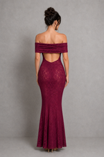 Woman wearing a burgundy off-shoulder lace dress against a gray background