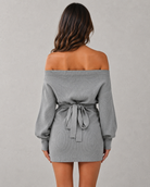 Gray off-shoulder dress with a belt on a plain background