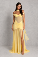 Woman wearing a yellow off-shoulder dress with a gray background