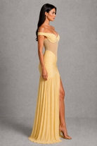 Woman wearing a yellow evening gown with a gray background