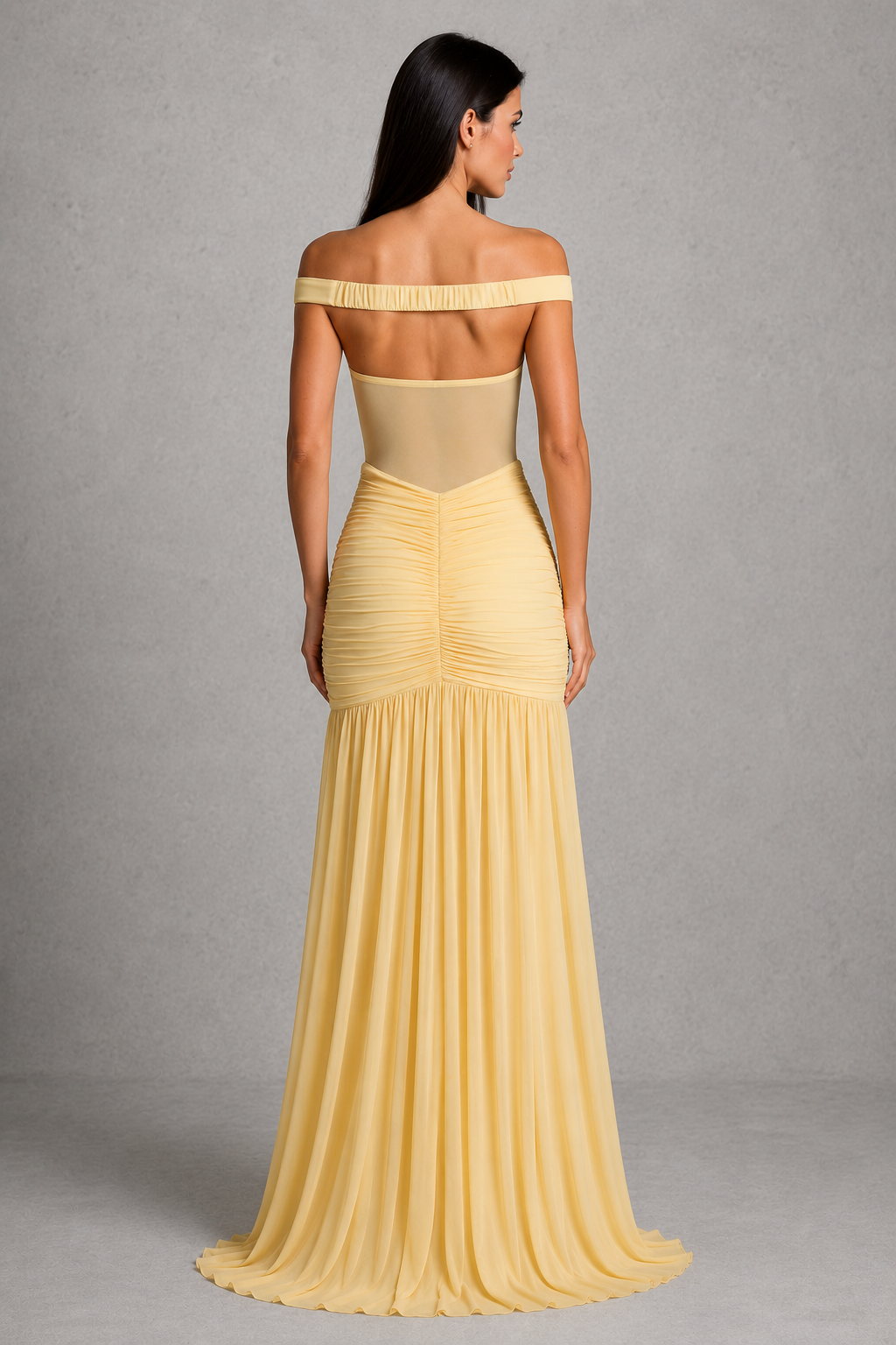 Woman wearing a yellow off-shoulder gown against a gray background
