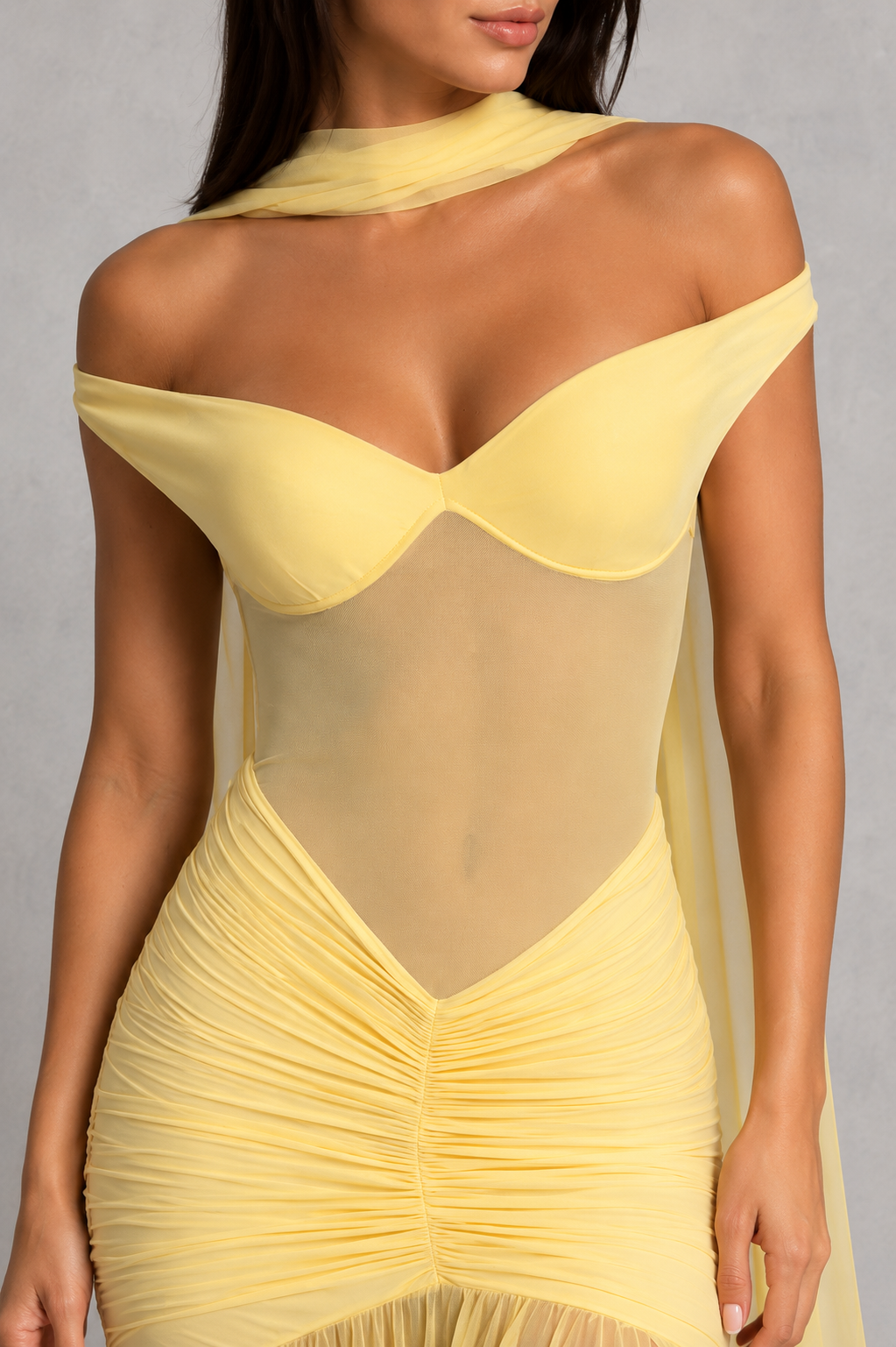 Yellow off-shoulder dress worn by a model on a gray background