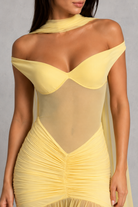 Yellow off-shoulder dress worn by a model on a gray background