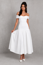 Woman wearing a white off-shoulder dress against a gray background