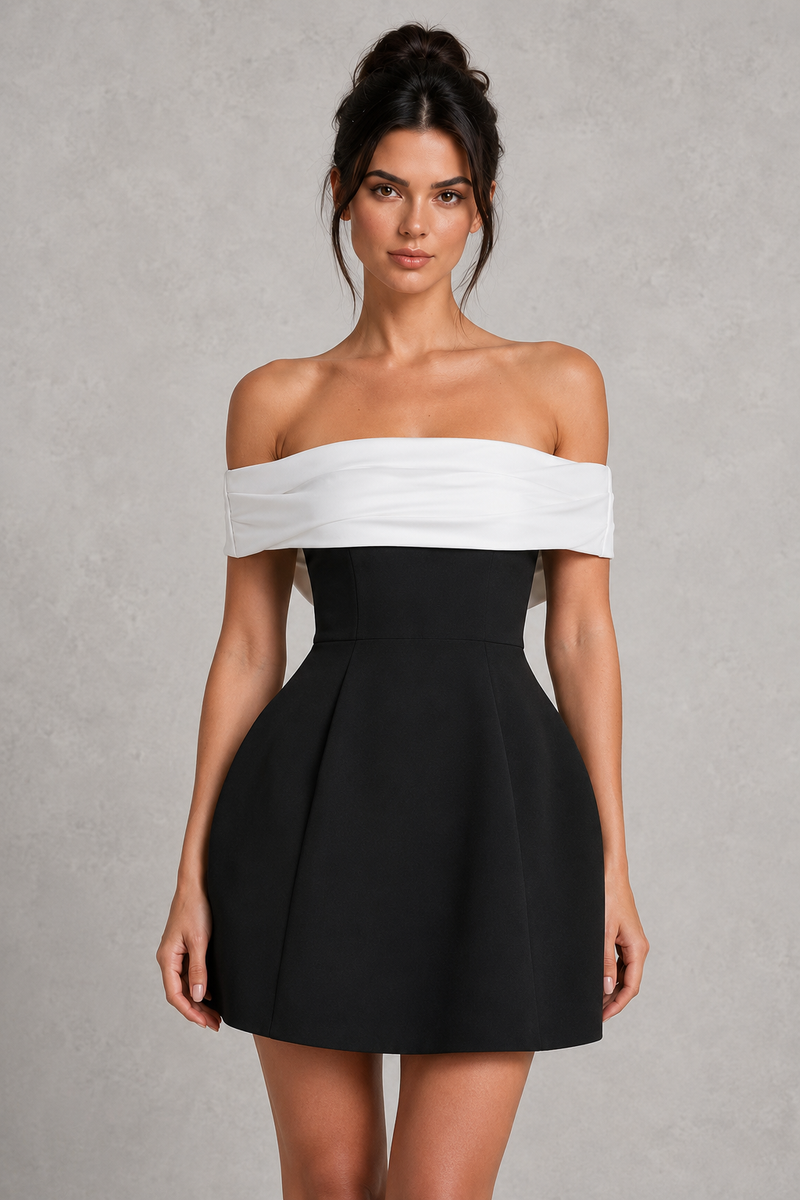 Woman wearing a black and white off-shoulder dress against a gray background