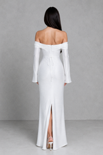 Woman wearing a white off-shoulder gown with a high slit on a gray background