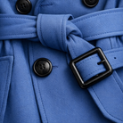 Close-up of a blue coat with black buttons and belt buckle