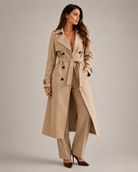 Woman wearing a gray trench coat on a plain background