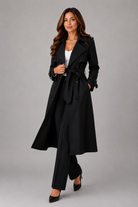 Woman wearing a gray trench coat on a plain background